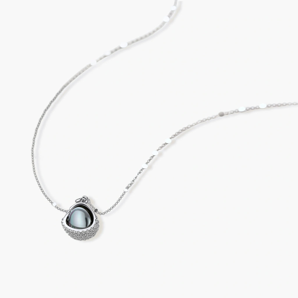White gold plated spherical jewelry set with zirconia crystal pavé and dark lustrous centers on neutral background.