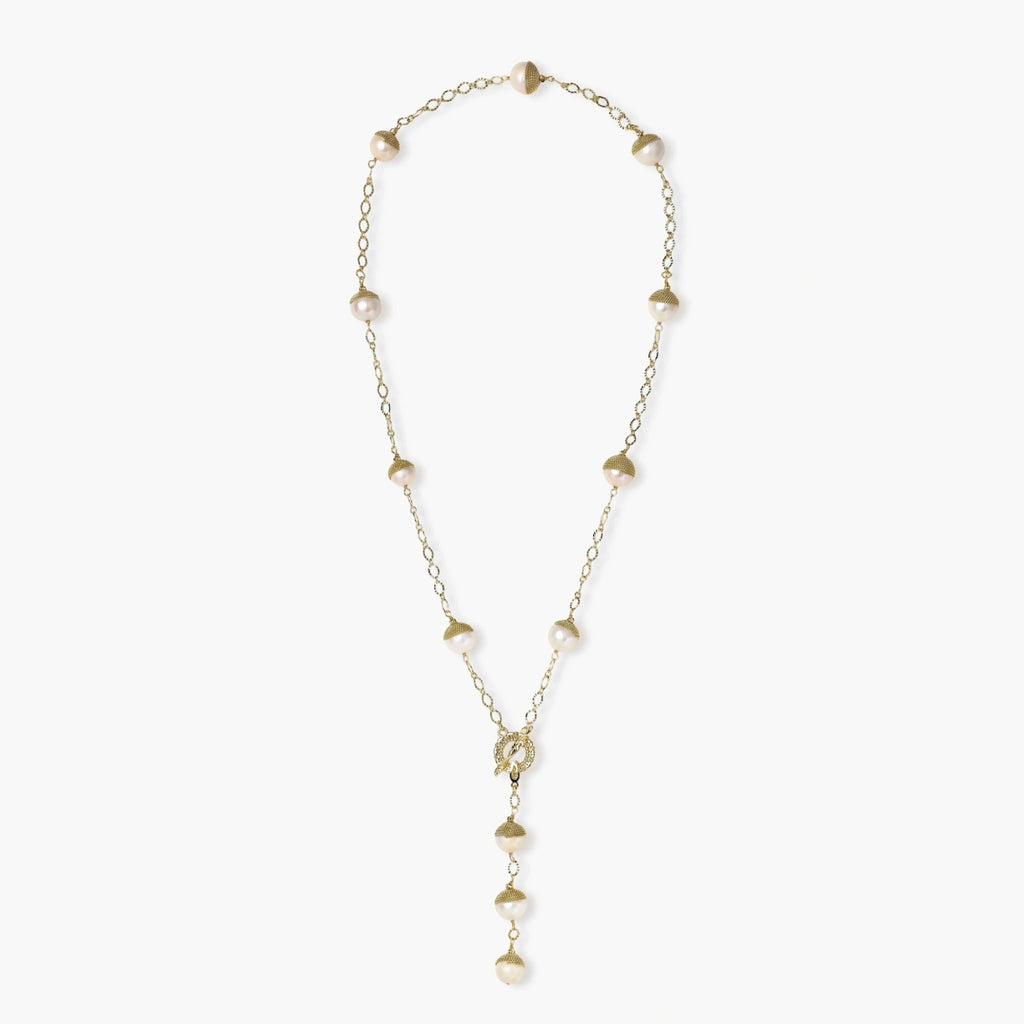 Gold-plated lariat necklace with baroque pearls and textured caps on cream background, showing adjustable Y-shaped design.