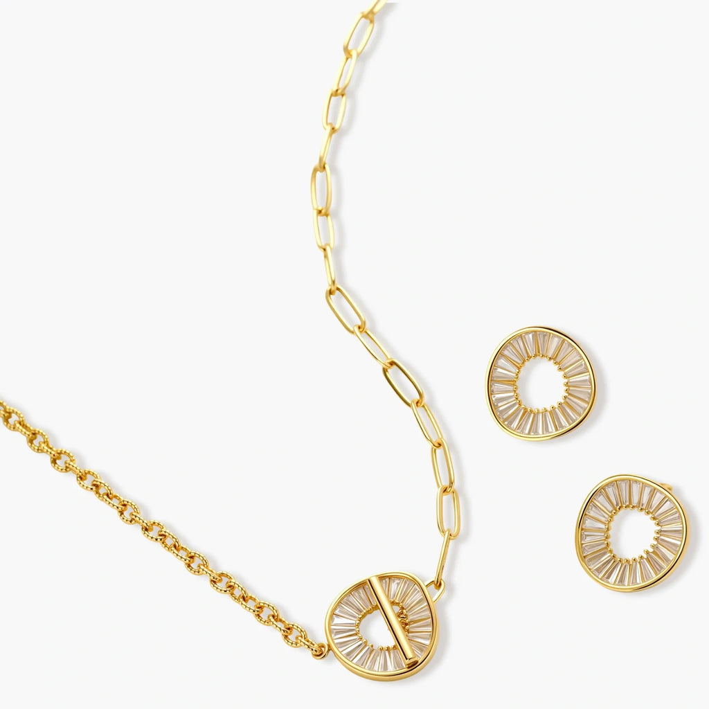 Gold-plated necklace and earring set with circular CZ crystal pendants featuring radial design on cream background