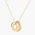 Organic-shaped gold pendant necklace with baroque pearl accent on adjustable chain, displayed against neutral background.