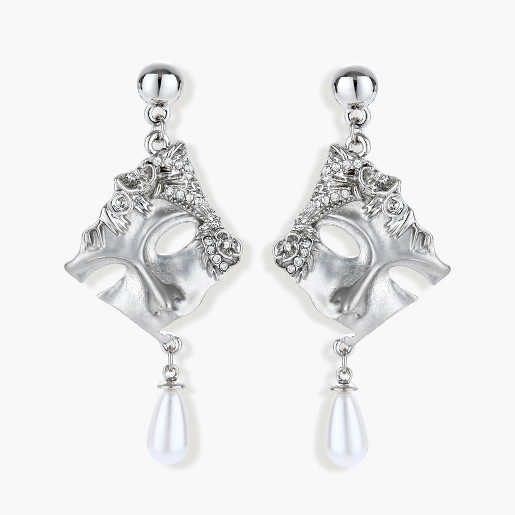 Ornate silver-toned theatrical mask earrings with crystal details and pearl drops on white background.