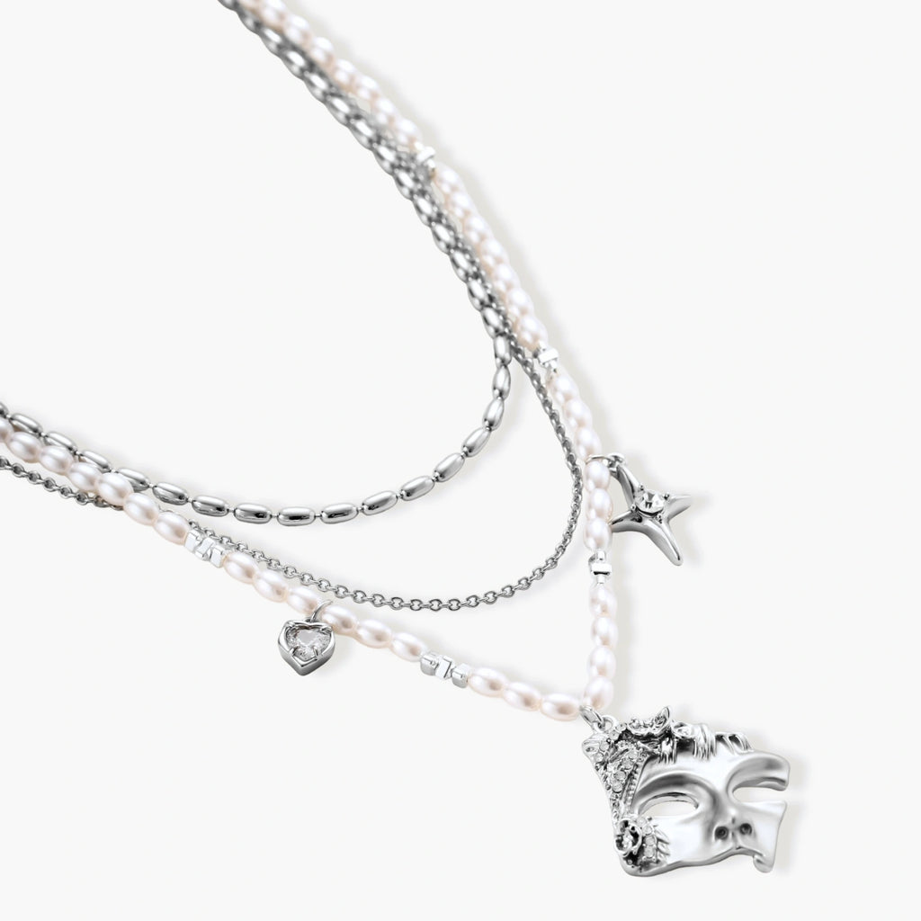 Multi-strand layered necklace set with silver chains, white pearls, star charm, heart pendant, and ornate decorative piece