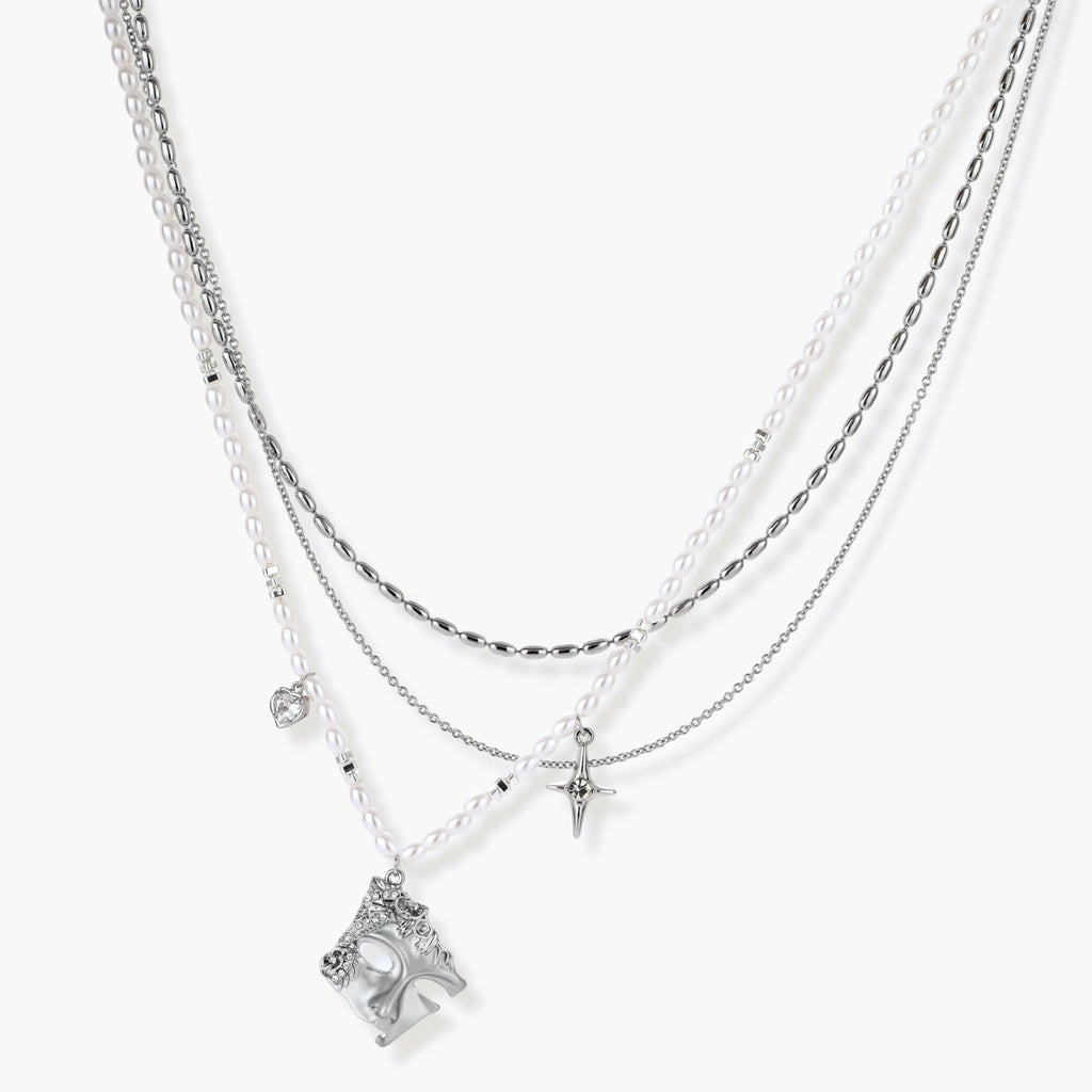 Multi-strand layered necklace set with silver chains, white pearls, star charm, heart pendant, and ornate decorative piece