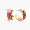 Sculptural gold-plated hoop earrings with diagonal purple and coral enamel stripes in twisted ribbon design