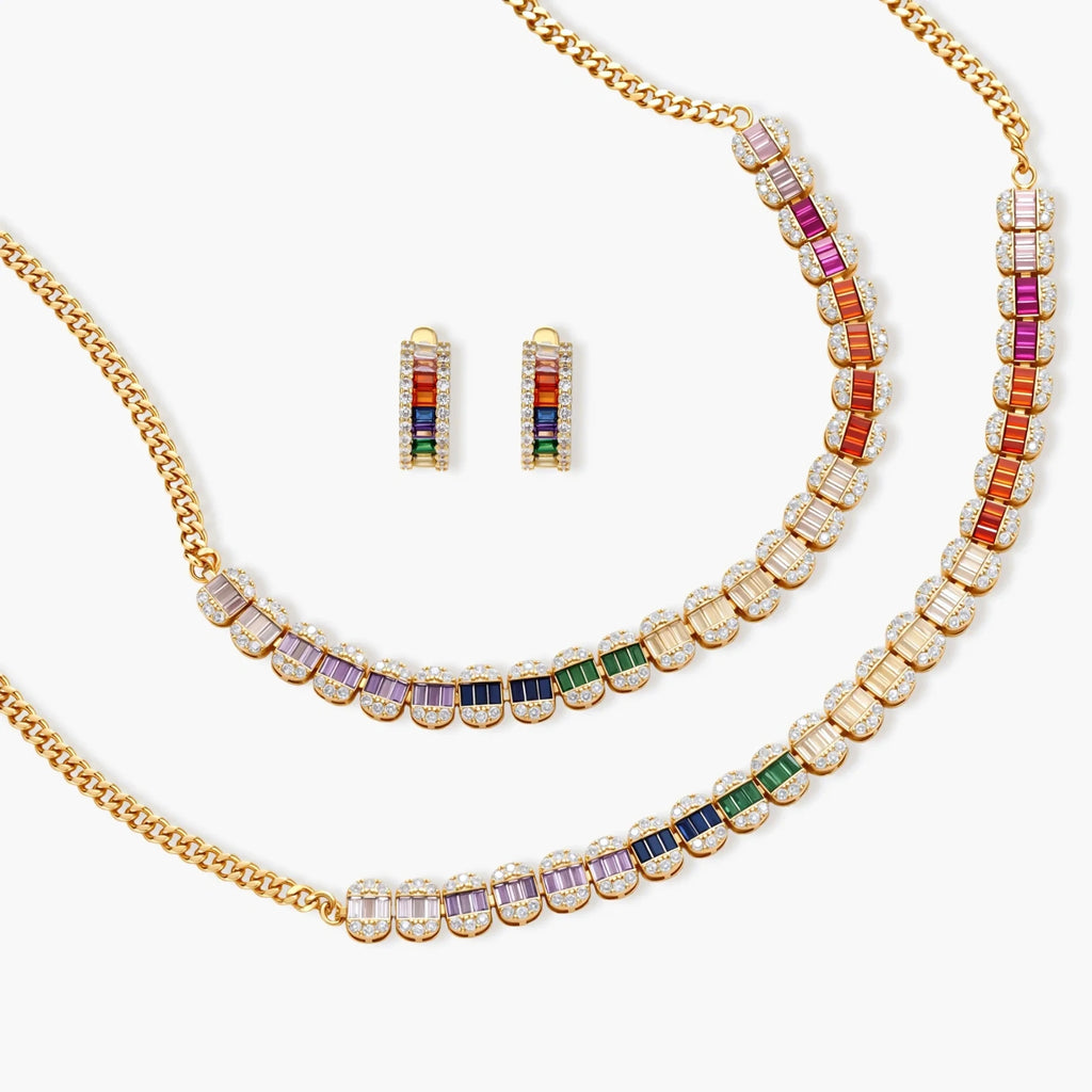 Gold-plated jewelry set featuring rainbow baguette-cut cubic zirconia stones in geometric design on cream background