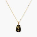 18k gold-plated necklace and earrings with green amber pendants featuring golden inclusions on cream background