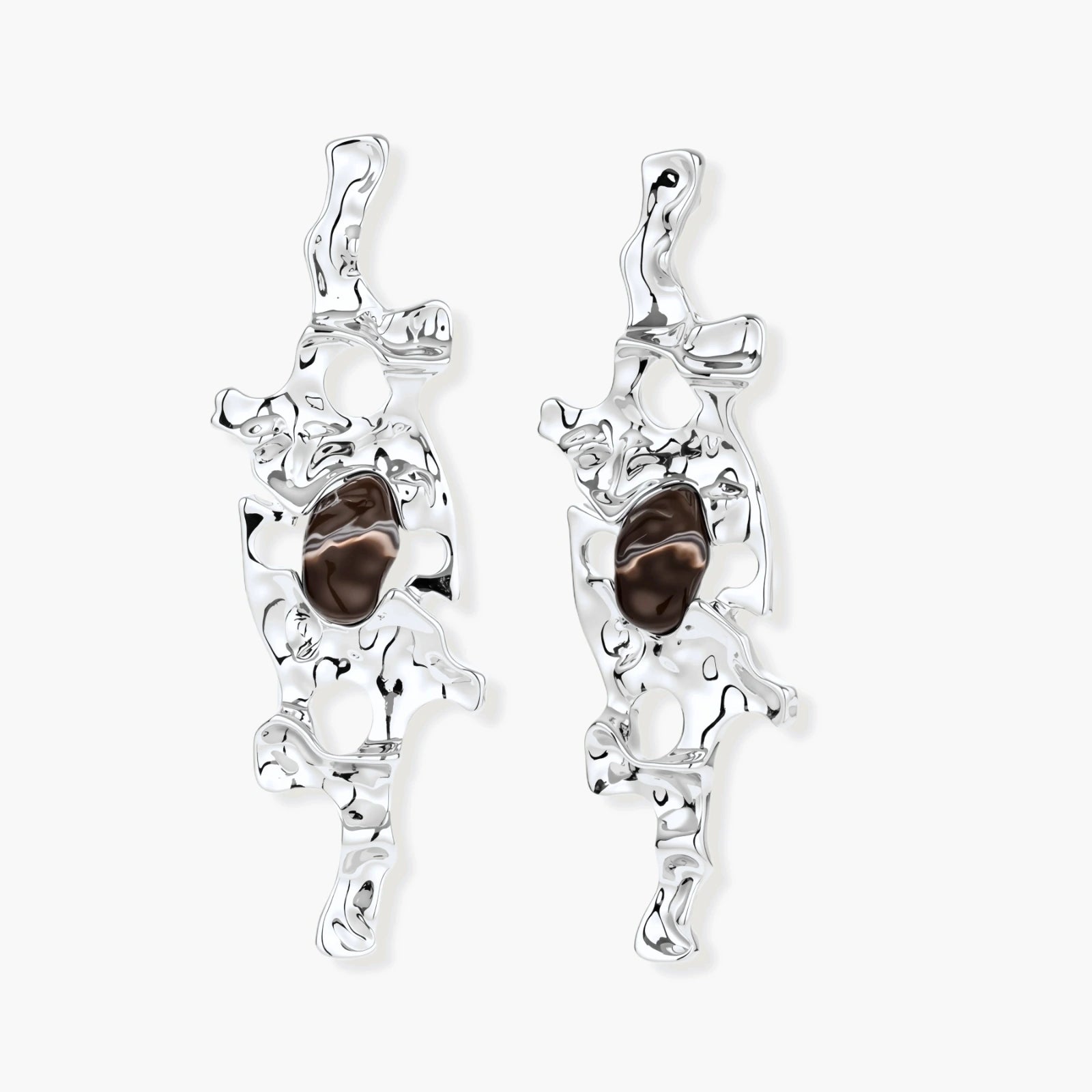 Flowing silver-toned earrings with organic liquid shapes and embedded brown resin stones on white background.