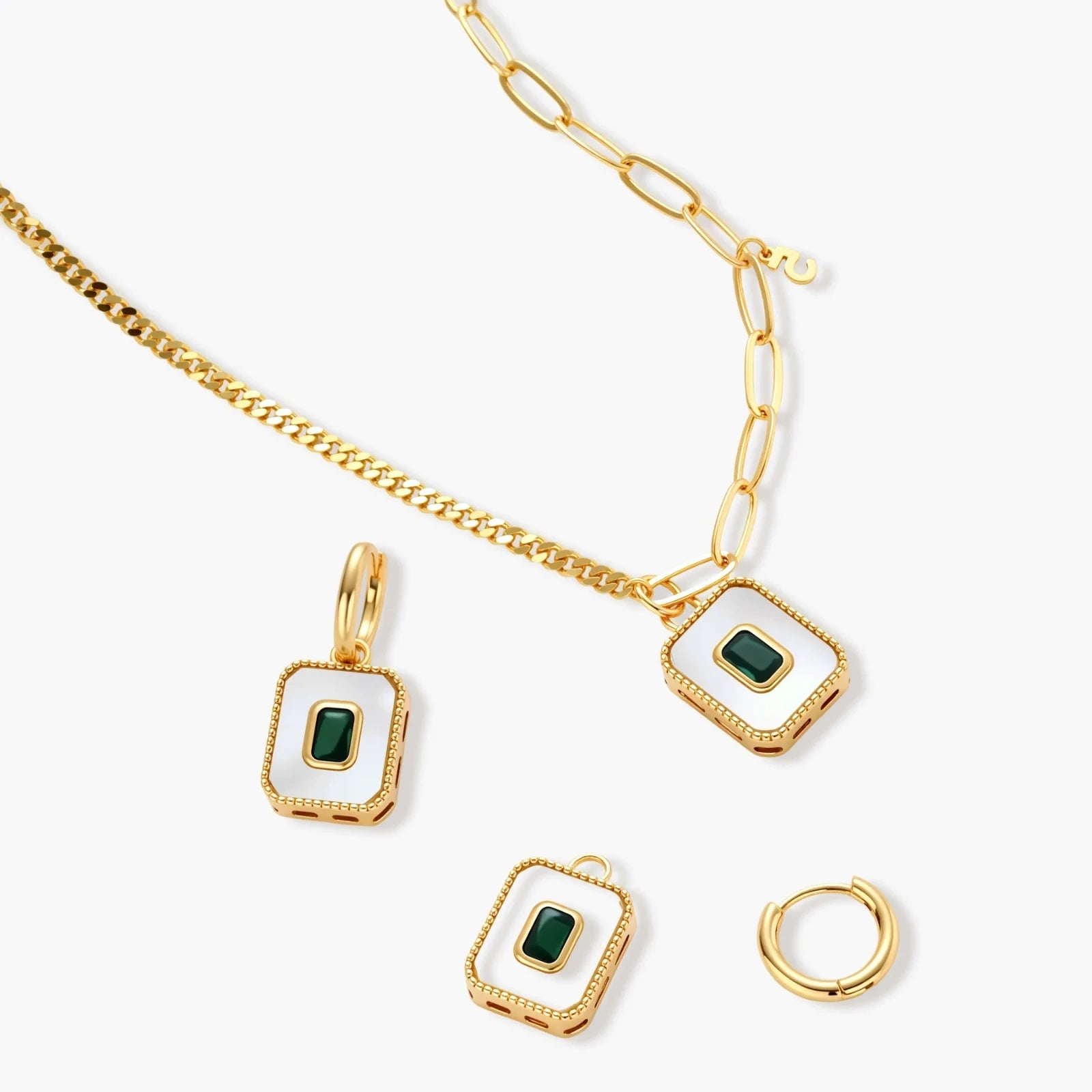 Gold-plated jewelry set with white enamel square pendants and emerald CZ stones on cream background.