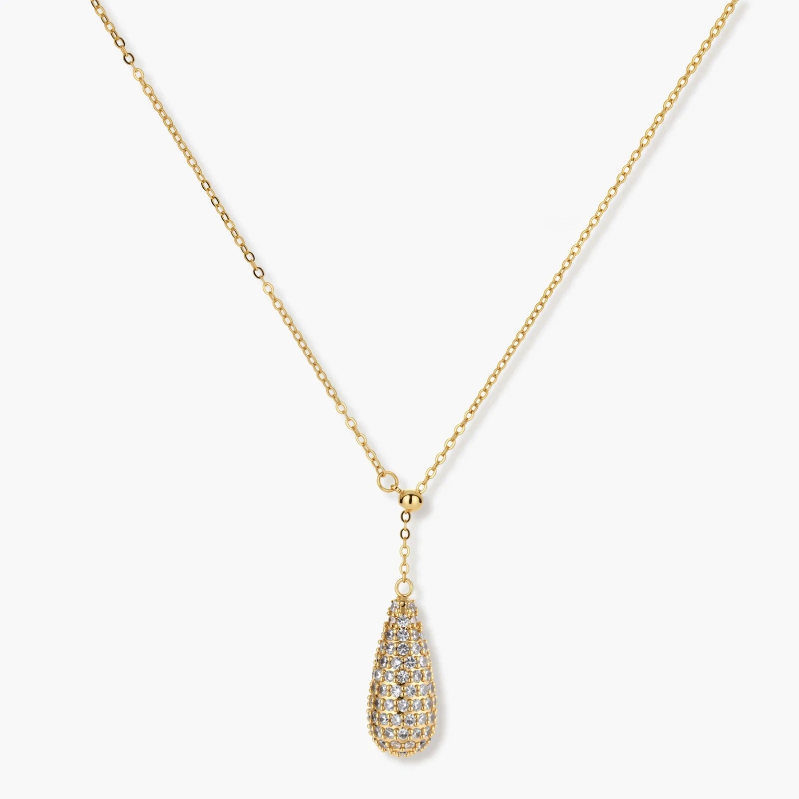 Gold-plated teardrop necklace and earrings covered in AAA cubic zirconia crystals on cream background.