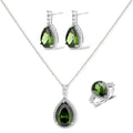 White gold plated jewelry set with green teardrop gemstones and cubic zirconia halos on cream background.