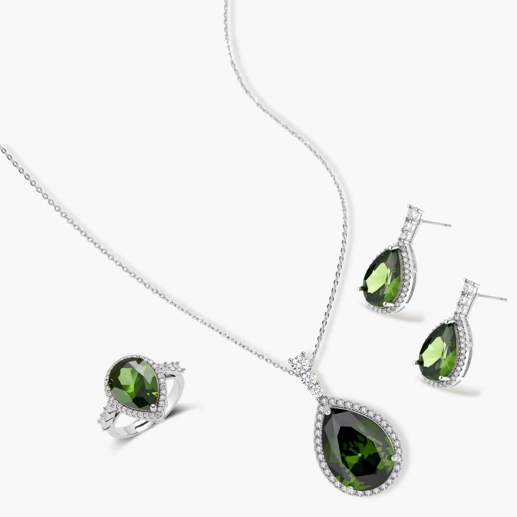 White gold plated jewelry set with green teardrop gemstones and cubic zirconia halos on cream background.