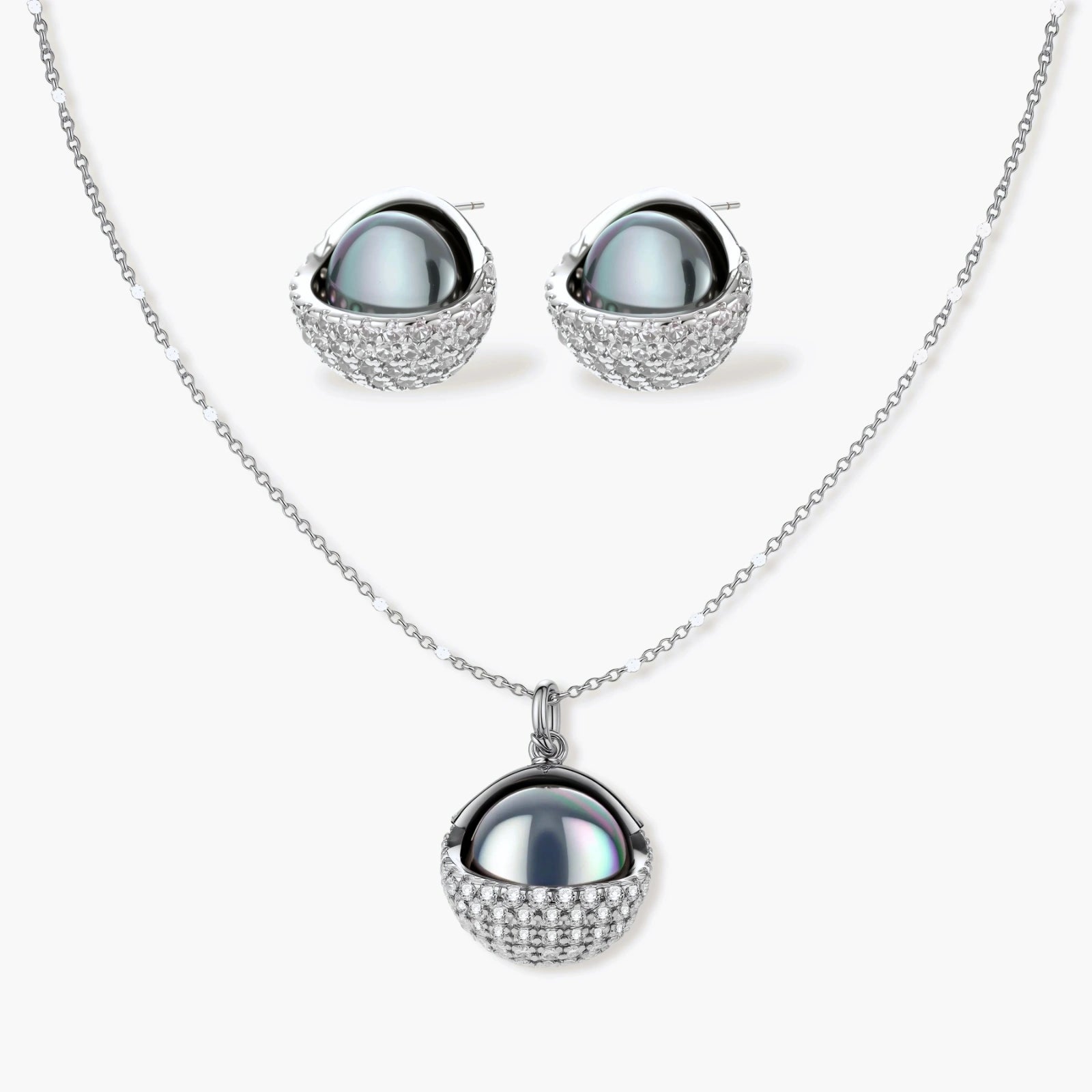 White gold plated spherical jewelry set with zirconia crystal pavé and dark lustrous centers on neutral background.
