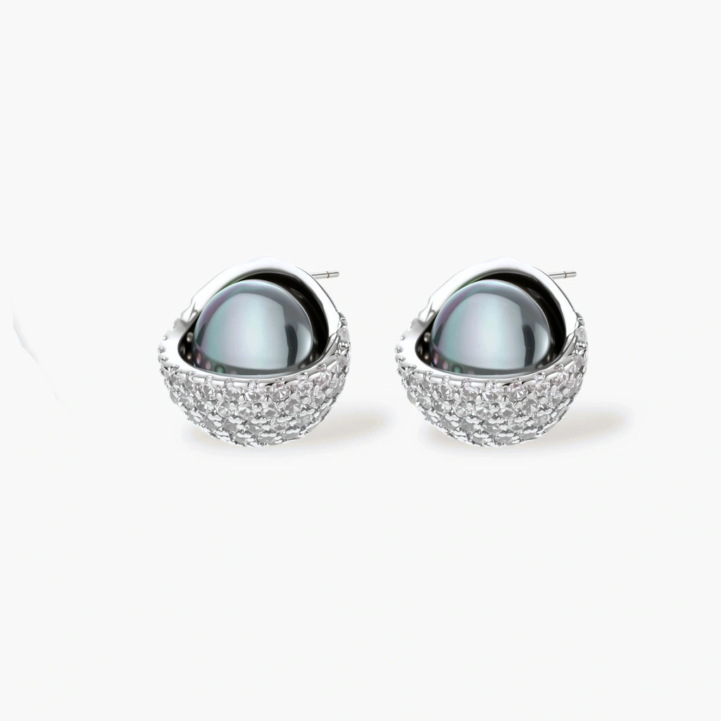 White gold plated spherical jewelry set with zirconia crystal pavé and dark lustrous centers on neutral background.
